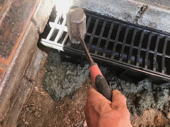 using a rubber mallet tap down the box drain in level needed