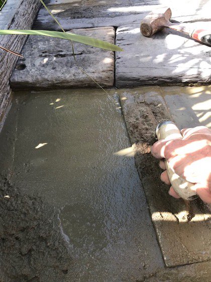 using a concreter's trowel to smooth the job