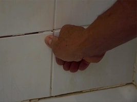 Tiles falling off the shower wall