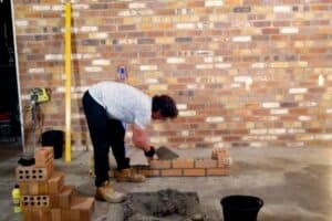 Marty demonstrating proper bricklaying technique in hands-on course lesson